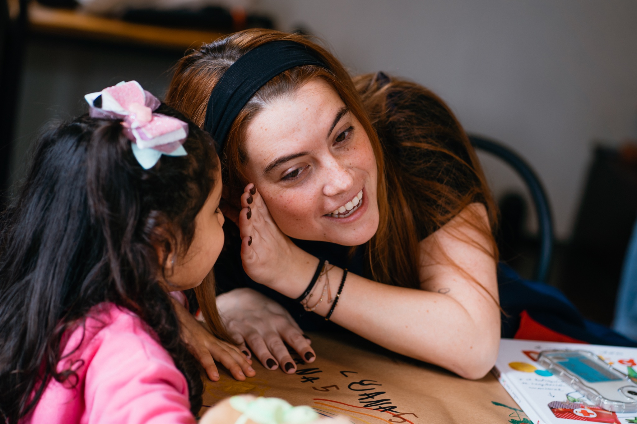 Maestra sonriendo junto a una niña en Play Date