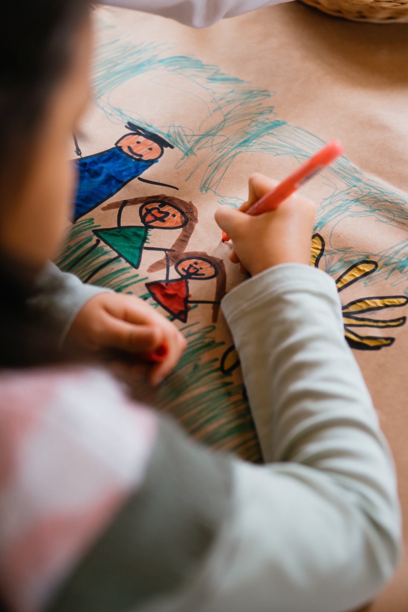 Manos de un niño dibujando con marcadores