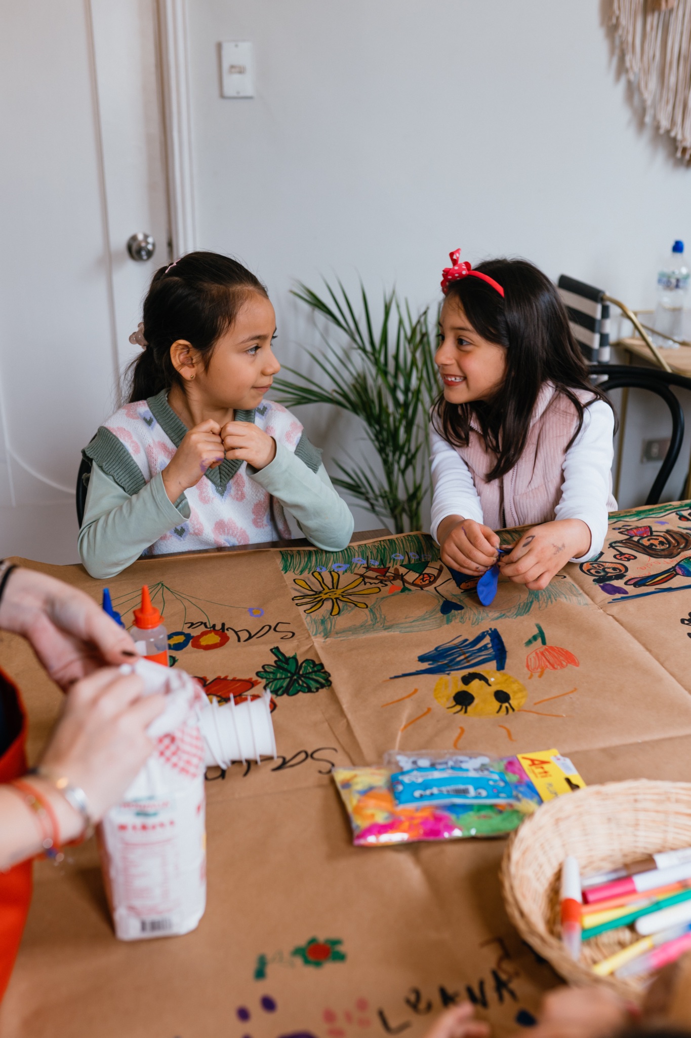 Niñas dibujando y conversando en la mesa de arte